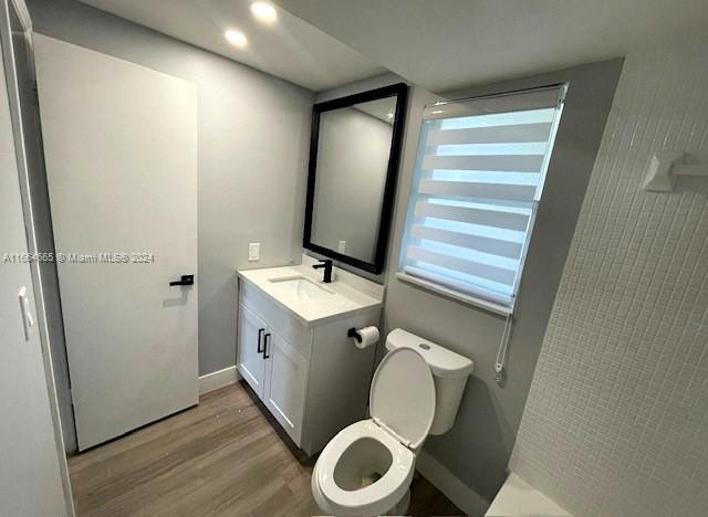 bathroom featuring vanity, hardwood / wood-style floors, and toilet