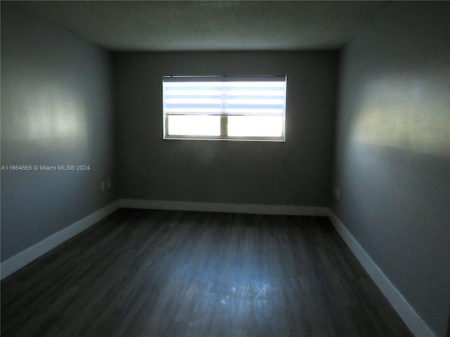 spare room with dark hardwood / wood-style floors