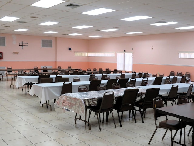 dining space featuring a drop ceiling and light tile patterned flooring