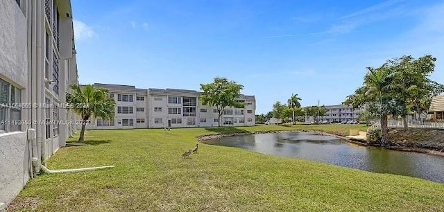 view of home's community with a lawn and a water view