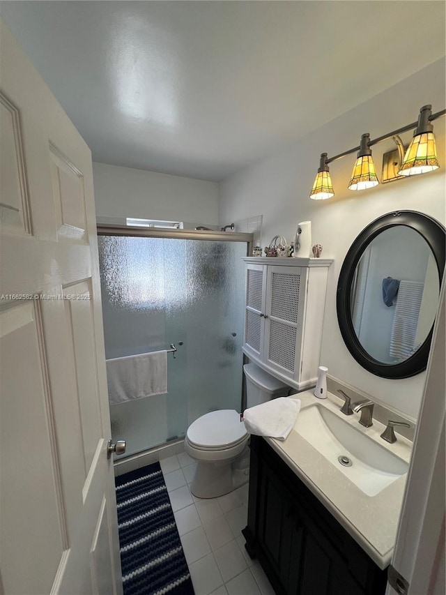 bathroom featuring tile patterned flooring, vanity, toilet, and walk in shower