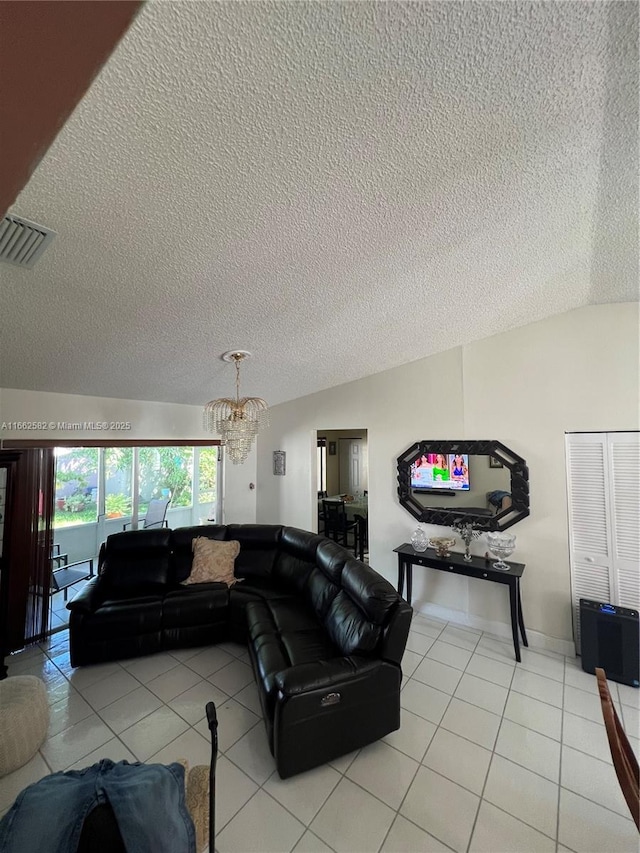 living room with lofted ceiling, light tile patterned flooring, a chandelier, and a textured ceiling