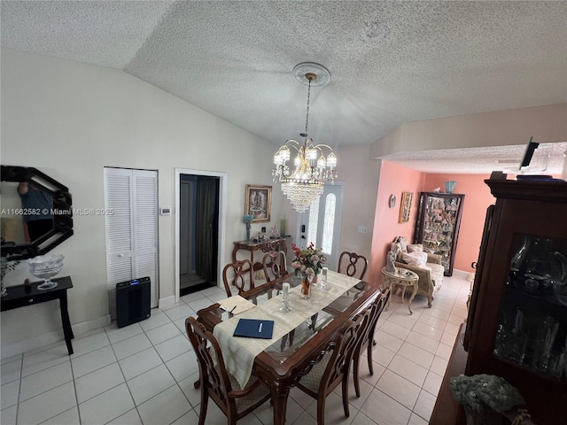 dining space with a notable chandelier, light tile patterned floors, a textured ceiling, and vaulted ceiling