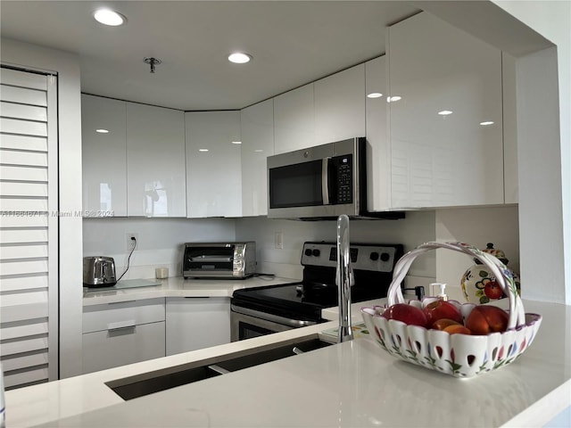 kitchen featuring appliances with stainless steel finishes and white cabinets