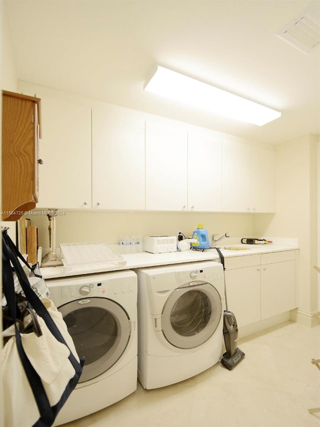 laundry area with washer and dryer, cabinets, and sink