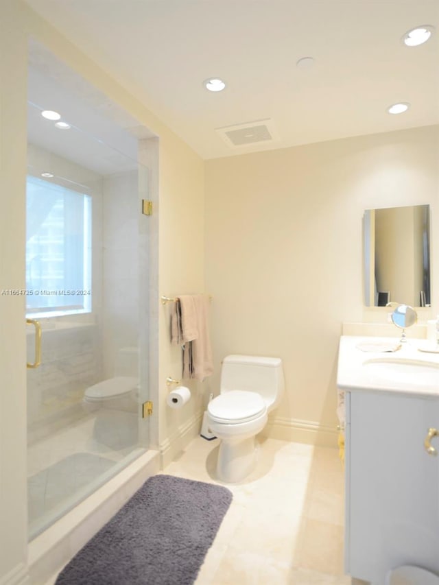 bathroom featuring vanity, toilet, and a shower with door