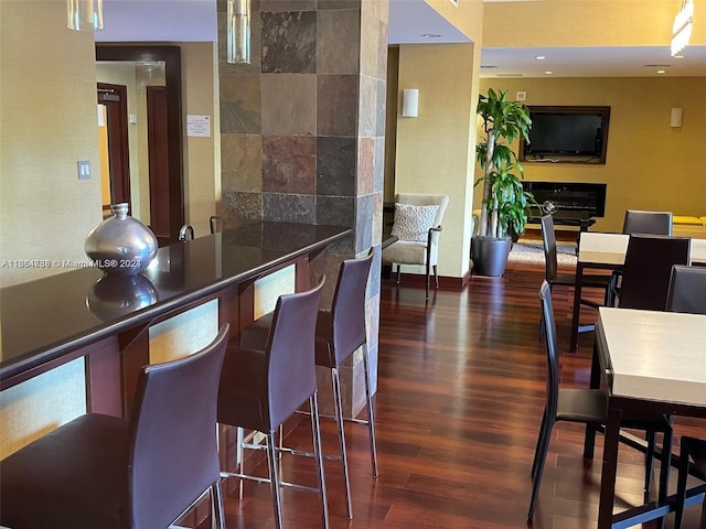 interior space with tile walls, a tile fireplace, and dark hardwood / wood-style flooring