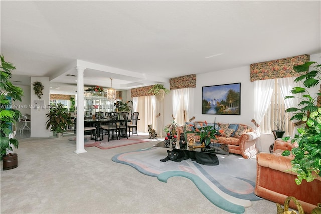 carpeted living room with decorative columns