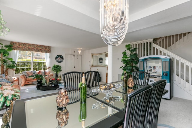 carpeted dining space with an inviting chandelier