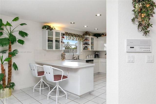 kitchen with white cabinetry, kitchen peninsula, a kitchen bar, and tasteful backsplash