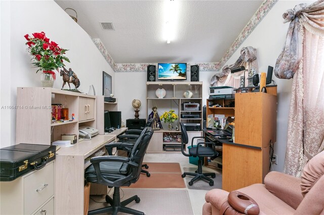 carpeted office featuring a textured ceiling