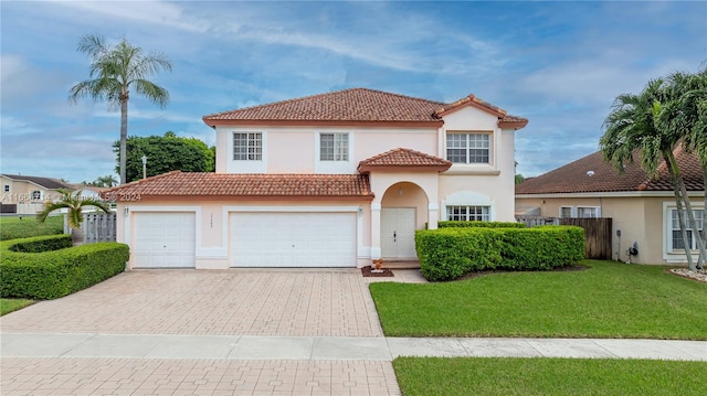 mediterranean / spanish-style home with a garage and a front lawn