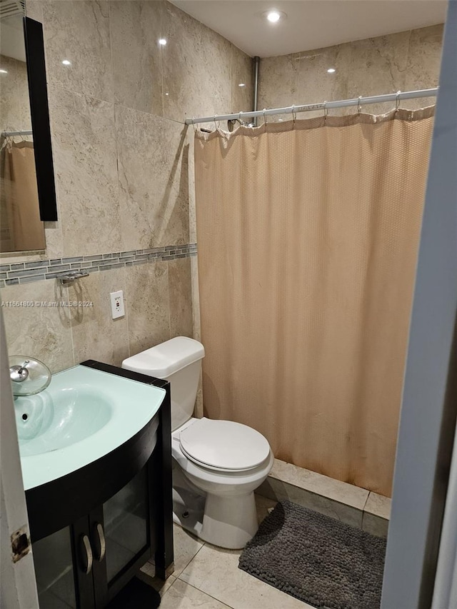 bathroom with vanity, tile walls, toilet, and curtained shower