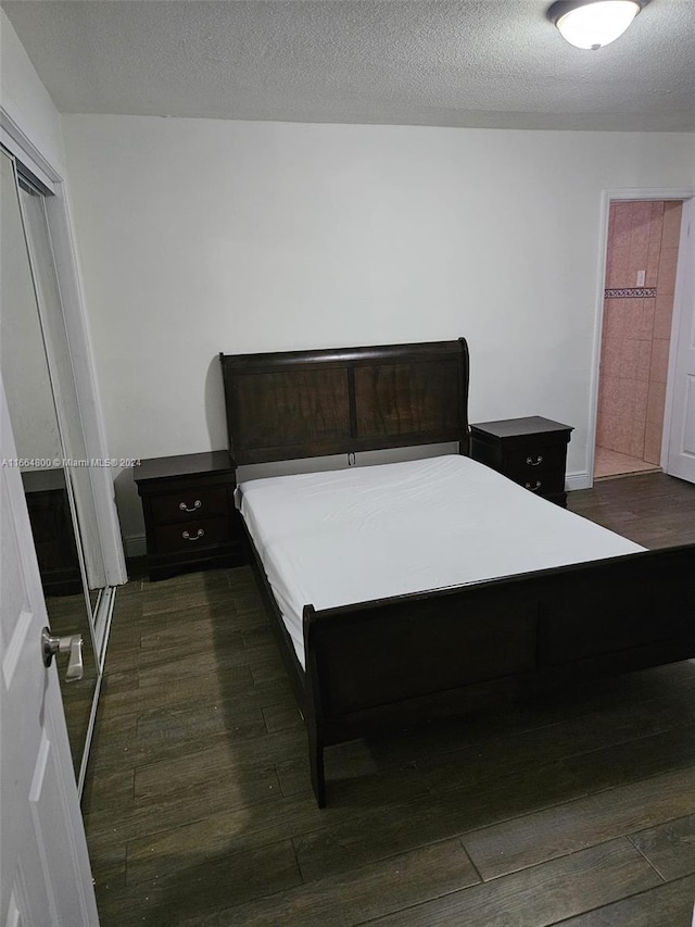 bedroom featuring a textured ceiling, a closet, and dark hardwood / wood-style floors