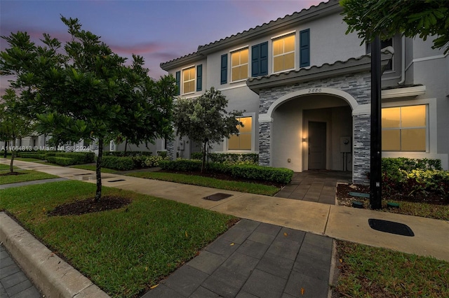 mediterranean / spanish home with a lawn