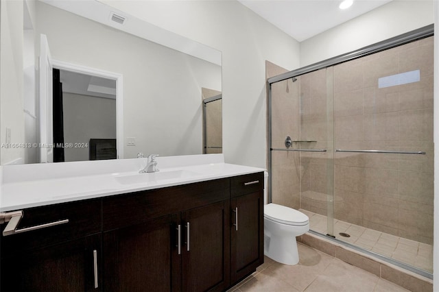 bathroom featuring tile patterned flooring, an enclosed shower, vanity, and toilet