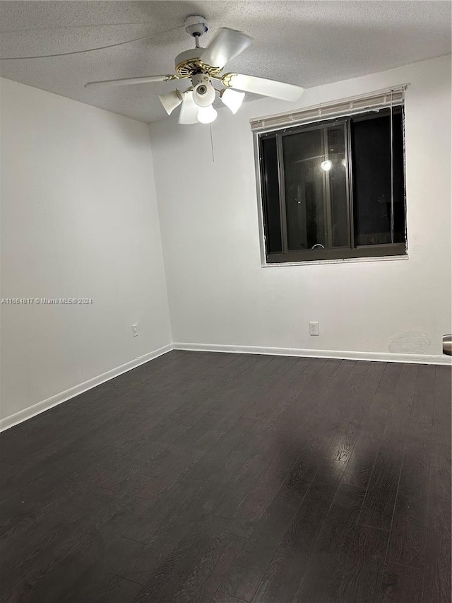 spare room with a textured ceiling, dark hardwood / wood-style flooring, and ceiling fan