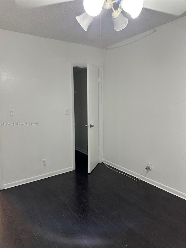 spare room featuring ceiling fan and dark wood-type flooring