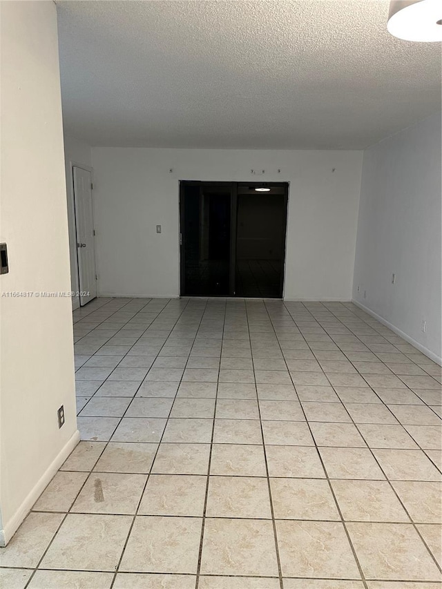 unfurnished room featuring light tile patterned floors and a textured ceiling