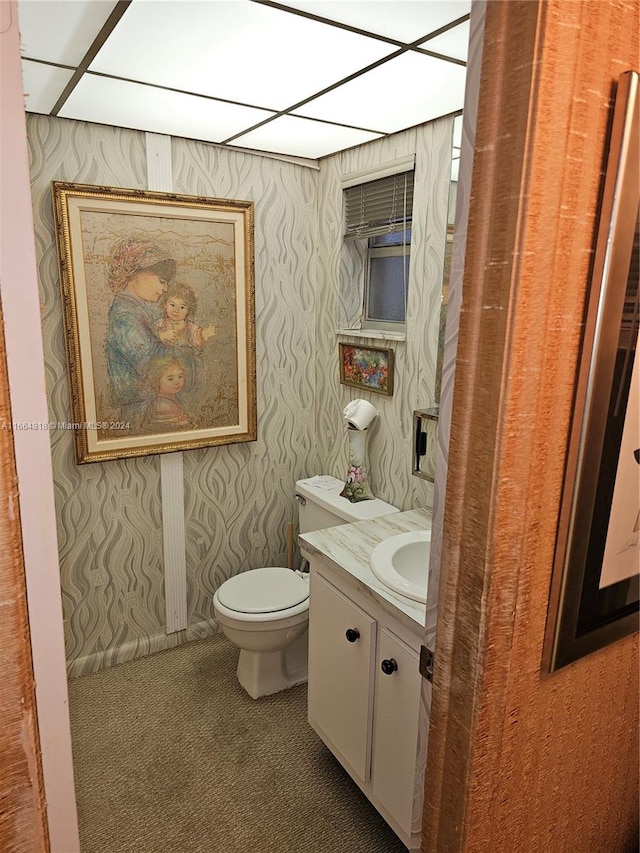 bathroom featuring a paneled ceiling, vanity, and toilet