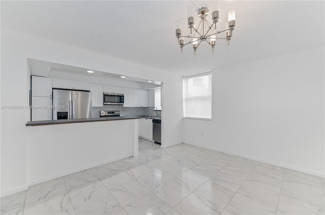 kitchen with a textured ceiling, sink, a notable chandelier, white cabinetry, and stainless steel appliances