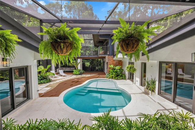 view of swimming pool featuring a lanai and a patio area