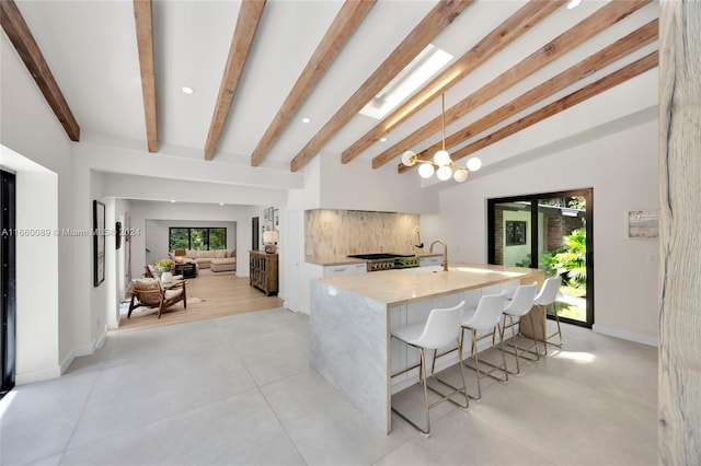 dining space featuring beam ceiling, a chandelier, and sink