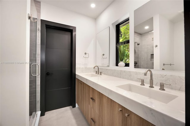 bathroom with backsplash, vanity, and an enclosed shower