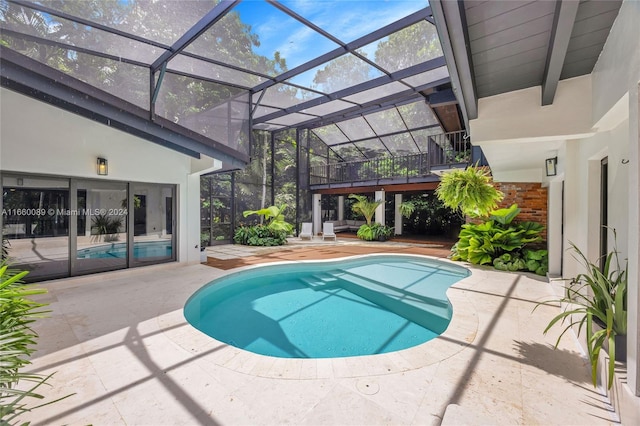 view of swimming pool with glass enclosure and a patio area