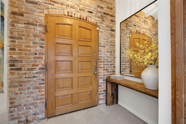 entryway featuring brick wall