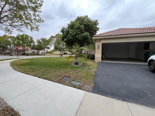 view of side of property featuring a garage and a lawn