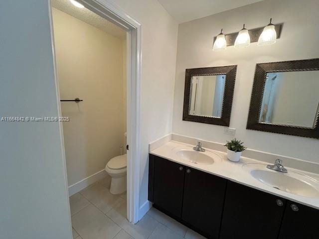 bathroom featuring tile patterned flooring, vanity, and toilet