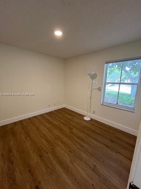 empty room with dark hardwood / wood-style flooring