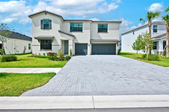 mediterranean / spanish house with a garage and a front lawn