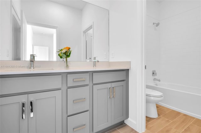 full bathroom featuring vanity, tiled shower / bath combo, and toilet