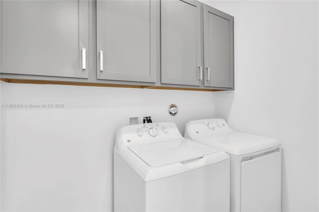 laundry room with washing machine and dryer and cabinets