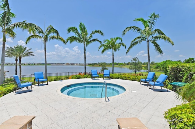 view of swimming pool featuring a water view, an in ground hot tub, and a patio area