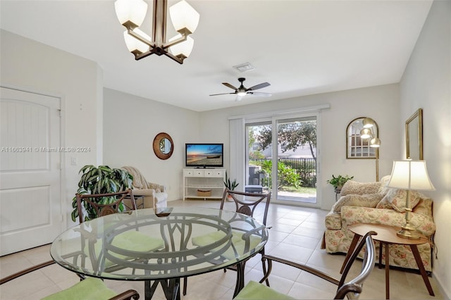 dining space with ceiling fan with notable chandelier and light tile patterned floors