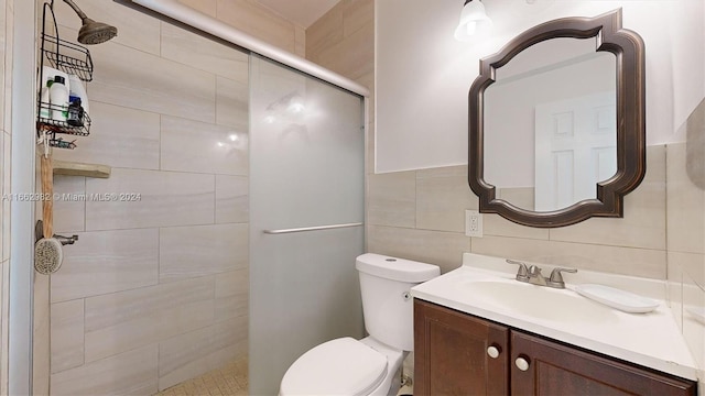 bathroom featuring vanity, tile walls, toilet, and an enclosed shower