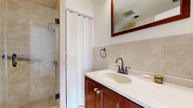 bathroom featuring vanity, tile walls, and a shower with door