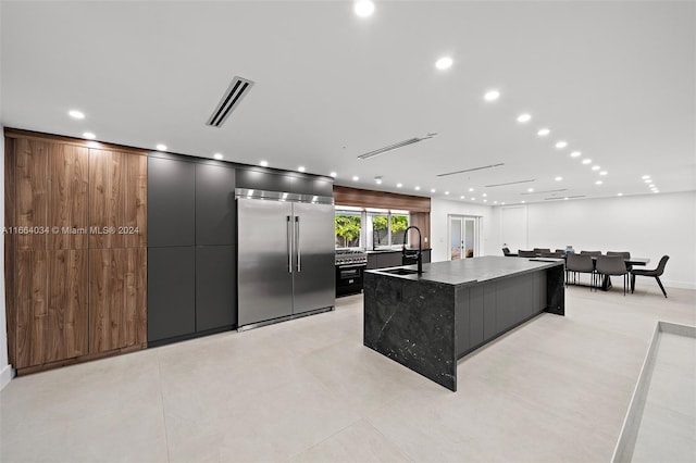 kitchen featuring stainless steel built in fridge, a spacious island, and sink