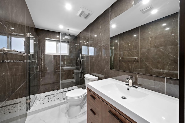 bathroom featuring vanity, tile walls, a shower with shower door, and toilet