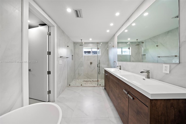 bathroom with tile walls, vanity, and separate shower and tub