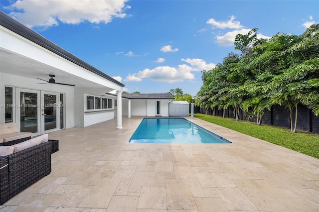 view of swimming pool with ceiling fan, a shed, french doors, a patio area, and an outdoor hangout area