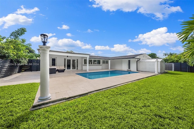 view of pool with a patio, a storage shed, a lawn, central AC, and french doors