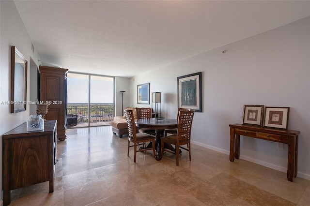 dining room with floor to ceiling windows and a textured ceiling