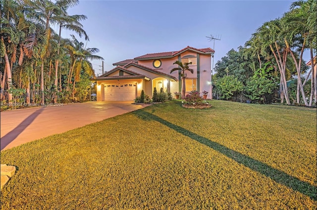 mediterranean / spanish-style house with a garage and a lawn