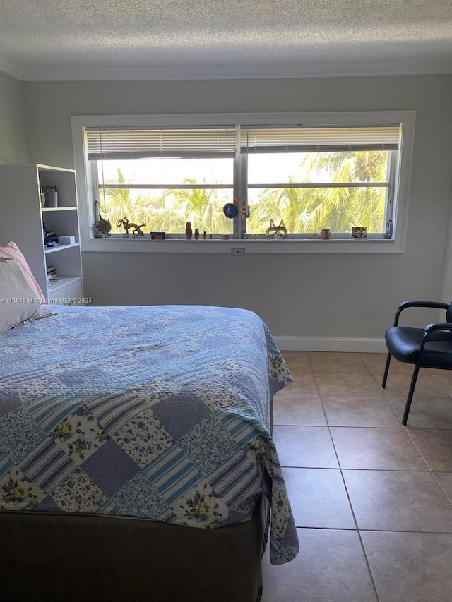 bedroom with a textured ceiling, light tile patterned floors, and multiple windows