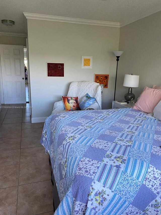 tiled bedroom with a textured ceiling and crown molding