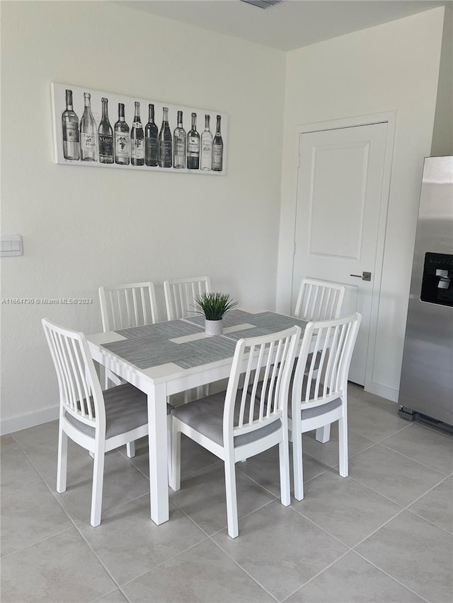 dining space with light tile patterned floors and bar